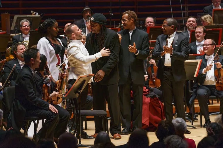 Conductor Yannick Nezet-Sequin (in white jacket) embraces composer Hannibal Lokumbe following the Philadelphia Orchestra premiere of "Healing Tones." Also shown are Mezzo-soprano Funmike Lagoke  (in white, left of Nezet-Sequin) and choral directors Eric Conway and J. Donald Dumpson (right of Nezet-Seguin).