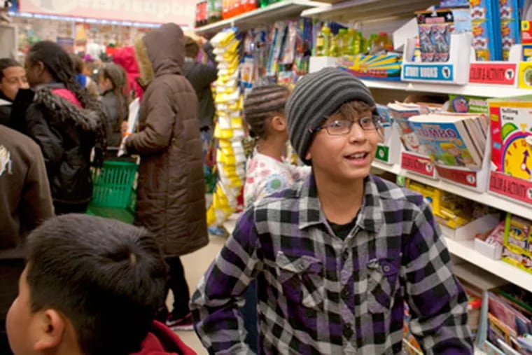 Irving Lopez, 9, participates in a shopping spree at a Dollar Tree store. (Ed Hille / Staff Photographer)