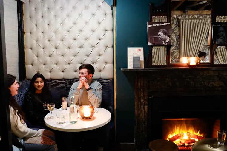 Jenna Shelby-Glick (left), Spoorthi Sampath (center), and Forrest Beaulieu sit in corner table at the 48 Record Bar, a vinyl-centric cocktail bar in Old City.