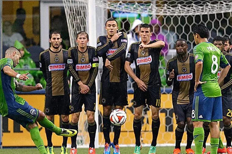 Union players make a wall as the Sounders' Clint Dempsey takes a penalty kick. (Ted S. Warren/AP)
