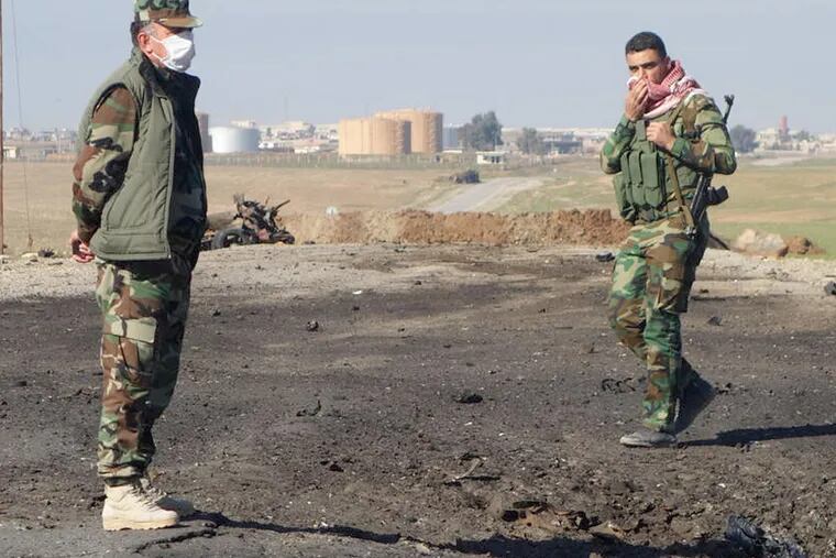 Kurdish soldiers survey the site of a bomb attack on a road between Mosul, Iraq, and the Syrian border where Kurdish authorities allege chlorine gas was used against peshmerga fighters.