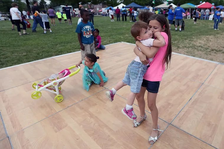 Ariana Severs, 9, gives her sister, Kali Rivera, 1, a kiss on the dance floor during Burlington Day on May 16, 2015. ( DAVID MAIALETTI / Staff Photographer )