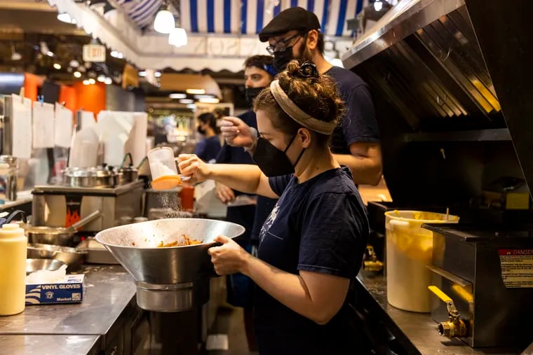 Rebecca Foxman, Owner of Fox & Son, works on seasoning fries for an order at Reading Terminal Market in Center City, Pa., on Wednesday, Aug., 11, 2021. Foxman, pays her team around $20/hour and strives to be as transparent and open with her staff as possible.