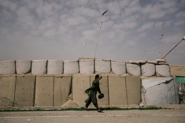 A soldier walks outside a military outpost in the village of Loy Mandah in Afghanistan's Helmand province on Feb. 24.