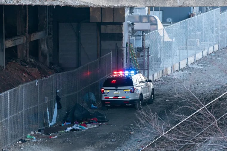 A police car at the scene of where skeletal remains were found underneath Market Street bridge near the Schuylkill River Trail on Tuesday.