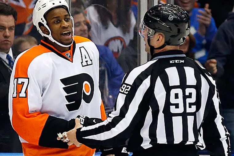 Flyers right wing Wayne Simmonds yells at a referee as linesman Mark Shewchyk restrains him. (Kathy Willens/AP)