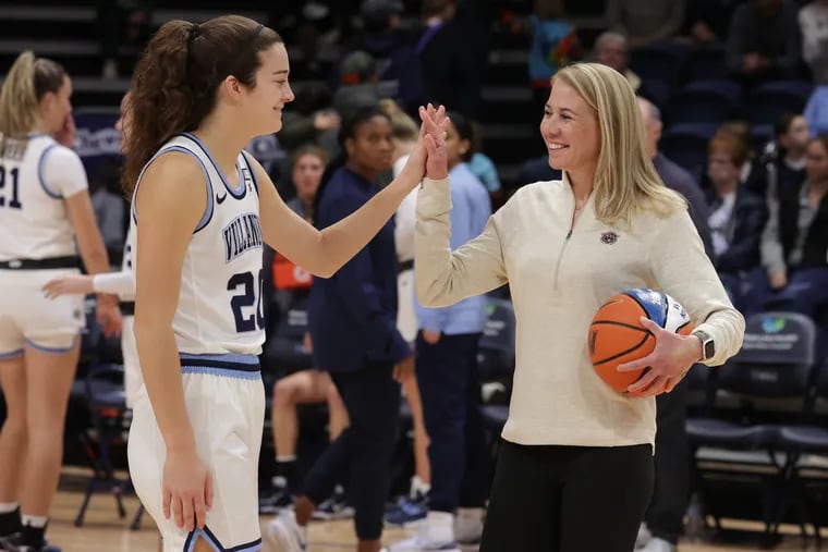 Maddy Siegrist (left) is presented with a ceremonial basketball by Coach Denise Dillon (right) of Villanova for scoring over 2,000 points in her career prior to the game against St. Joseph's on Dec. 10. A little over a month later, Siegrist set the all-time scoring record at Villanova on both the men's and women's programs.