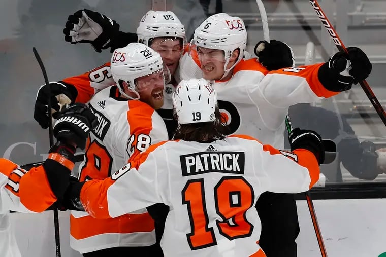 Flyers defenseman Travis Sanheim celebrates his overtime-winning goal with teammates Monday night in Boston. The victory keeps the Flyers in the thick of the playoff hunt.