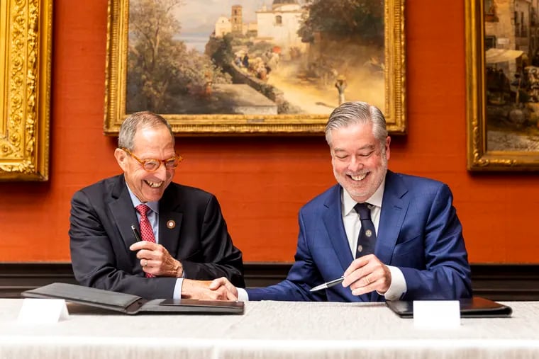 Salus University President Michael Mittelman and Drexel University President John Fry shake hands after signing documents for a merger at the Anthony J. Drexel Picture Gallery in Philadelphia on Tuesday.