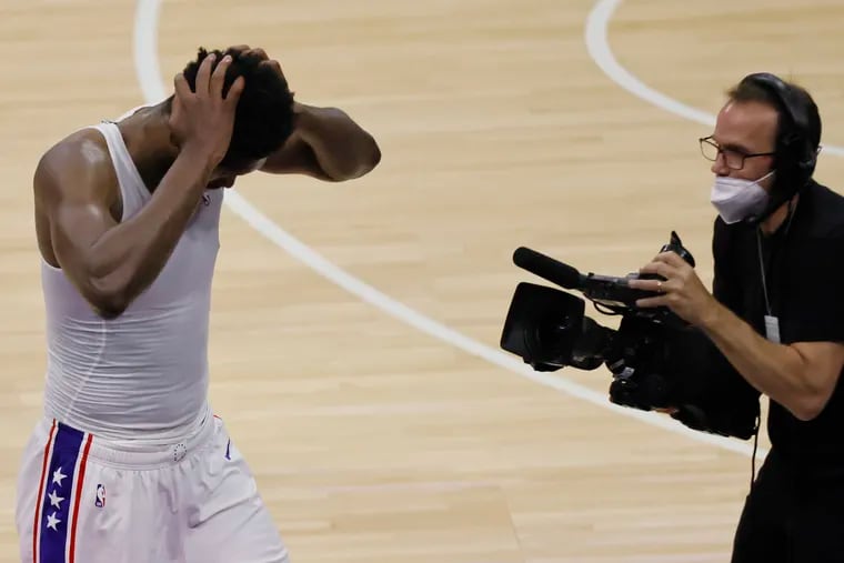 Sixers center Joel Embiid holds his head as he walks off the court after the team's Game 7 loss to the Atlanta Hawks.