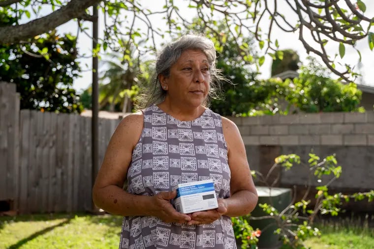 Kailini Ross holds a box of albuterol, a medication to prevent shortness of breath, in Lahaina, Hawaii on May 2. Ross has been suffering from multiple respiratory issues since last year’s wildfire. MUST CREDIT: Mengshin Lin for The Washington Post