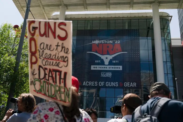 People gather outside the George R. Brown Convention Center to protest the National Rifle Association's annual meeting in Houston on Friday.