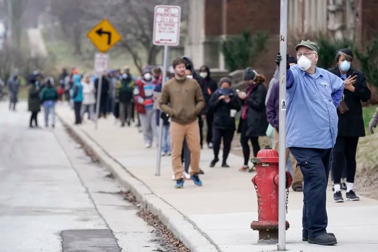 In this April 7 photo, voters observe social distancing guidelines as they wait in line to cast ballots in the presidential primary election in Milwaukee.