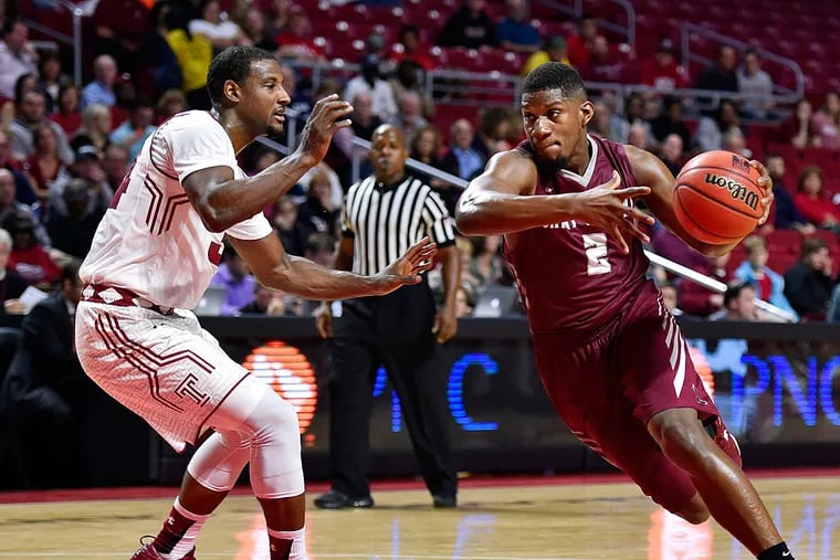 Saint Joseph's Hawks guard Aaron Brown (2) dribbles past Temple Owls guard Devin Coleman (34) during the first half at Liacouras Center.