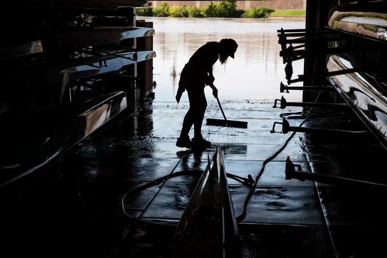 Jen Wesson cleans mud out of the University Barge Club boathouse on Boathouse Row, following flooding in August from Tropical Storm Isaias. Flooding is possible from Elsa Thursday night into Friday.