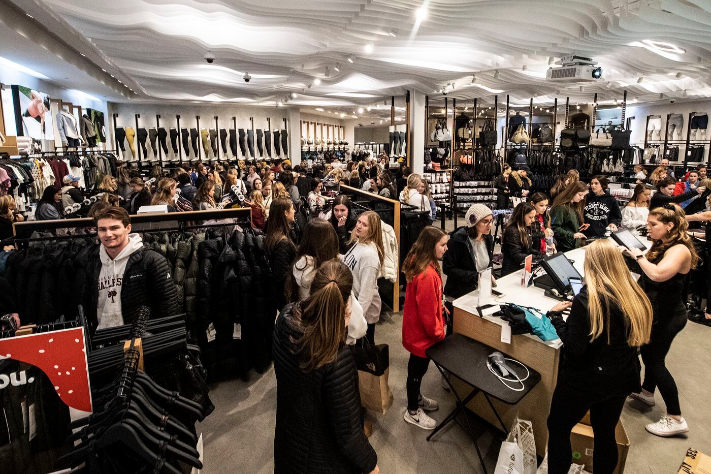 Shoppers exit the Lululemon store during a Black Friday sale at the King of Prussia Mall.