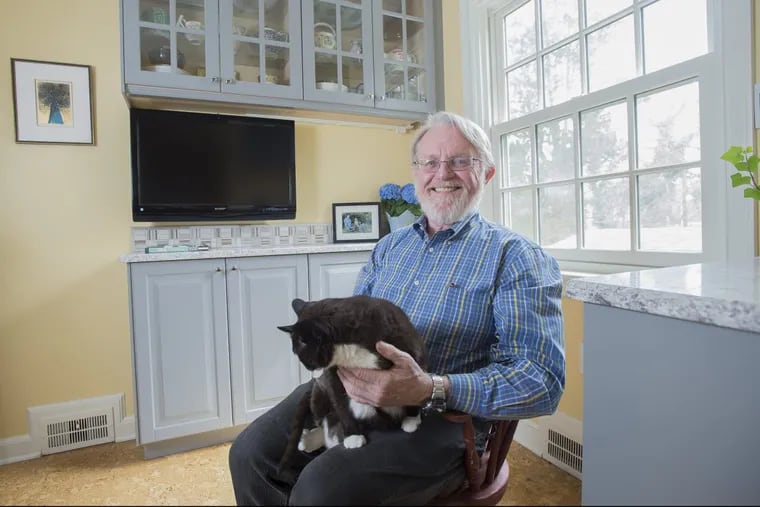 John Basinski with his cat Luna in the new pantry of his Jenkintown home. Smaller cabinets replaced the existing ones to create space.