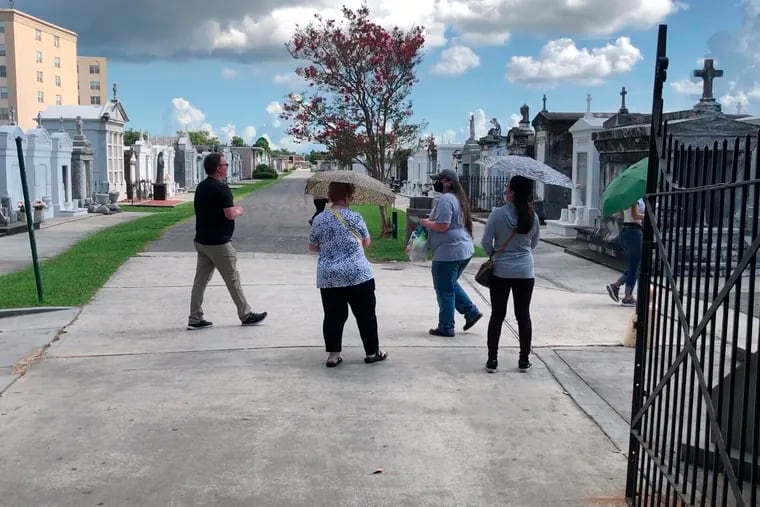 Tourists wander through a historic New Orleans cemetery on Thursday, Aug. 12, 2021. The city’s vital tourism industry was devastated by the COVID-19 epidemic in 2020. It had begun making a comeback in recent months as vaccines have become available. But the spread of the highly contagious delta variant of the coronavirus and a low vaccination rate in Louisiana are being blamed for a resurgence of COVID-19 that has stressed hospitals and led to cancellations, for the second year, of tourist-drawing events. (AP Photo/Kevin McGill)