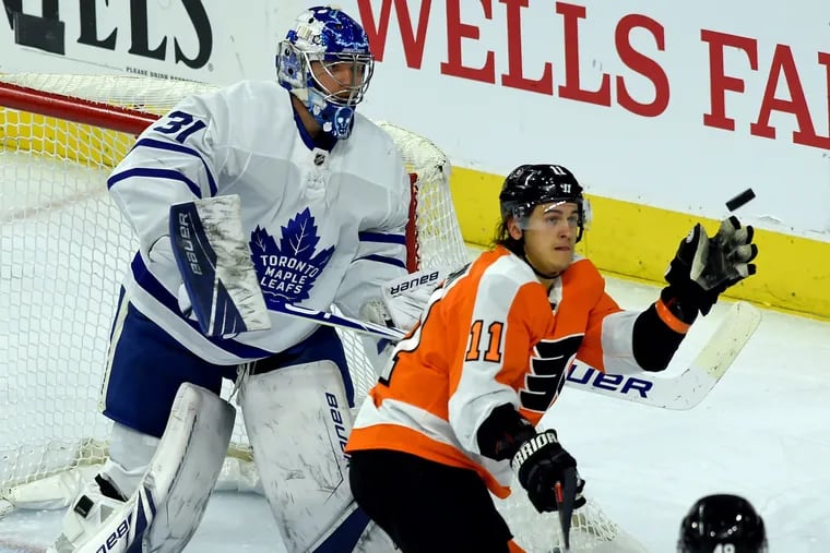 The Flyers' Travis Konecny  handling  an airborne puck in front of Toronto Maple Leafs goalie Frederik Andersen, in the second period Tuesday.