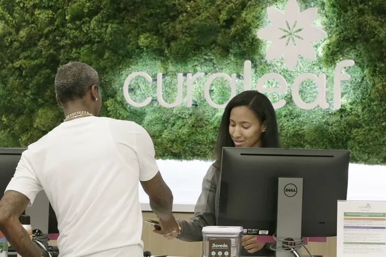 Curaleaf dispensary associate Deja Mack assists a customer in the Curaleaf dispensary in Bellmawr, NJ on May 24, 2018. New Jersey lawmakers have unveiled their latest proposal to legalize recreational marijuana for people 21 and over.