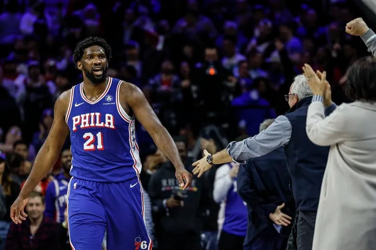 Joel Embiid celebrates with fans in the front row in the final minute of the Sixers' win over Denver.