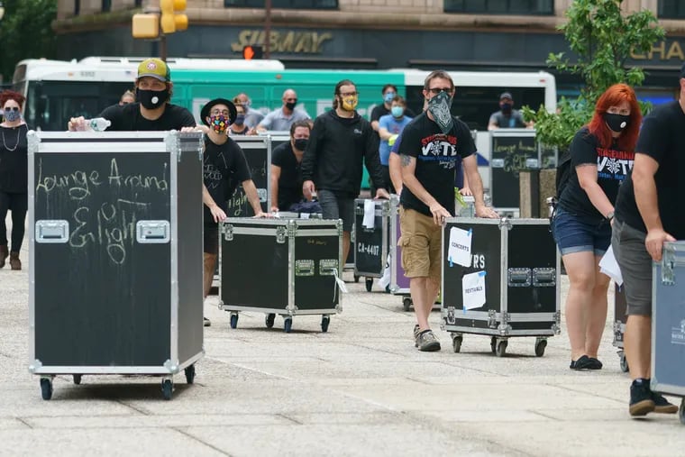 Members of the Philly chapter of Live Events Coalition push their road cases around City Hall as part of a rally to call attention to the financial hit their industry is taking from COVID-19 closures.