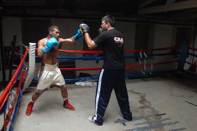 Palestinian boxer Ahmad Tuba (left) in a training session with his Israeli trainer Ranny Tal (cq) in the ring at Masjid Muhammad mosque in North Philadelphia.  Tuba makes his professional debut this Friday at the Blue Horizon. ( Clem Murray / Staff Photographer )