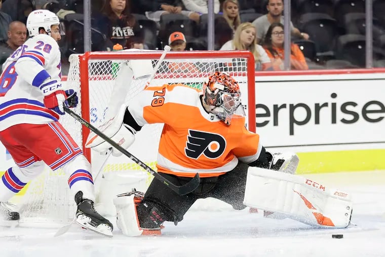 “I added some muscle, added some durability,” said Carter Hart, making a save against the Rangers' Phillip Di Giuseppe in a preseason game. “I feel really healthy in the net, really strong.”