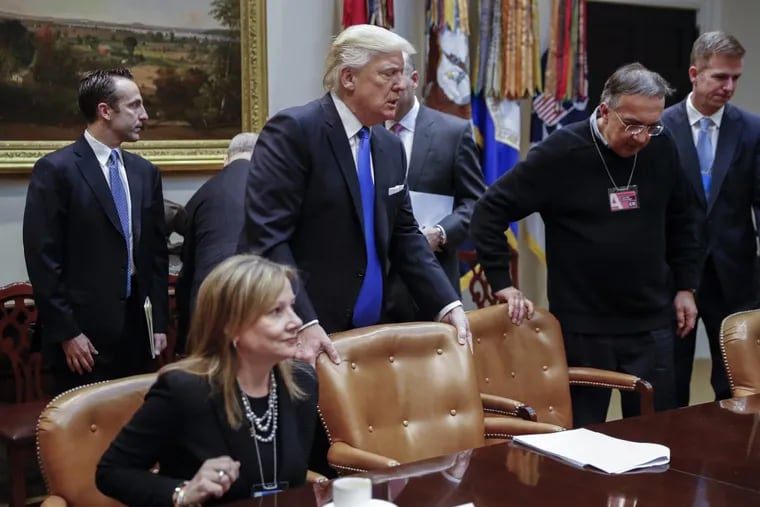President Trump (center) with CEO of General Motors Mary Barra (left) and CEO of Fiat Chrysler Automobiles Sergio Marchionne (second from right) takes his seat prior to delivering remarks to automobile industry leaders during a meeting in  on Jan. 24, 2017.