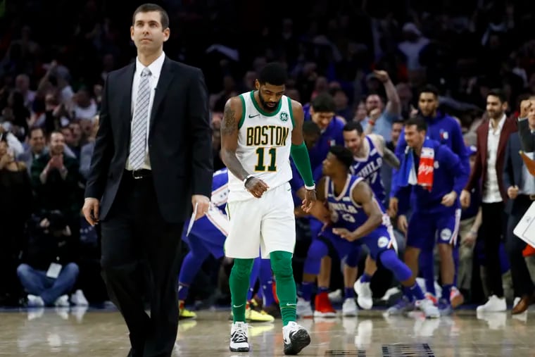 Boston Celtics' Kyrie Irving, center, and coach Brad Stevens, left,  walk the court for a timeout after Jimmy Butler scored a basket during the second half of an NBA basketball game on March 20 in Philadelphia. The Celtics lost 115-118.