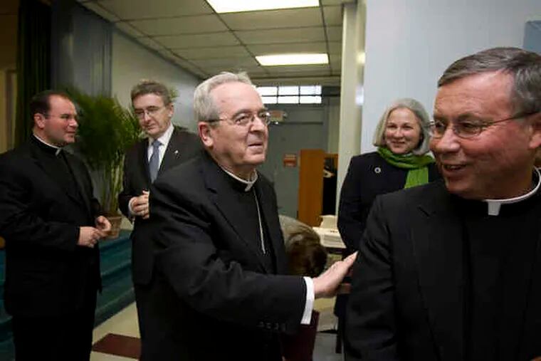 Cardinal Justin Rigali greets Msgr. Francis Beach, chairman of the priests&#0039; advisory committee. Behind them (from left) are the Rev. Kevin Gallagher and Jim Delaney, of the cardinal&#0039;s leadership task force, and Jacki Delaney.