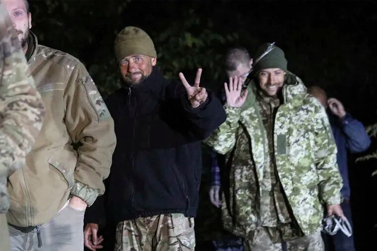 In this photo provided by the Ukrainian Security service Press Office, Ukrainian soldiers, who were released in a prisoner exchange between Russia and Ukraine, smile near Chernihiv, Ukraine, late Wednesday.