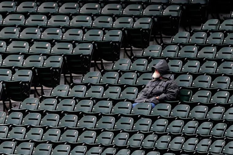 A fan braves the cold weather during the seventh inning of an baseball game between the White Sox and Twins. (Paul Beaty/AP)