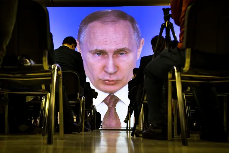 Journalists watch as Russian President Vladimir Putin gives his annual state of the nation address in Manezh in Moscow, Russia, on March 1, 2018. (AP Photo/Alexander Zemlianichenko)