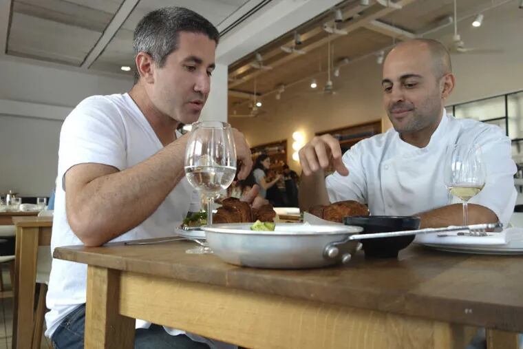 "In Search of Israeli Cuisine": Michael Solomonov (left) joins Meir Adoni over kubaneh, a Yemenite sabbath bread, at Adoni's Mizlala restaurant. He also owns the upscale Catit and kosher Blue Sky.