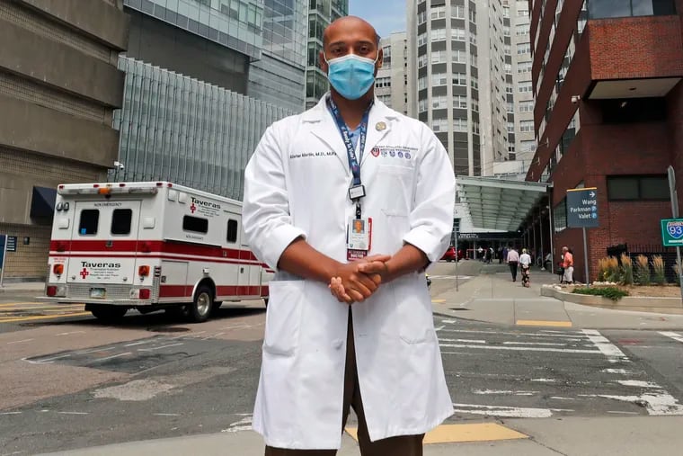 Alister Martin, an emergency room doctor at Massachusetts General Hospital, poses outside the hospital, Friday, Aug. 7, 2020, in Boston. Martin founded the organization "VotER" to provide medical professionals voter registration resources for patients who are unregistered voters.