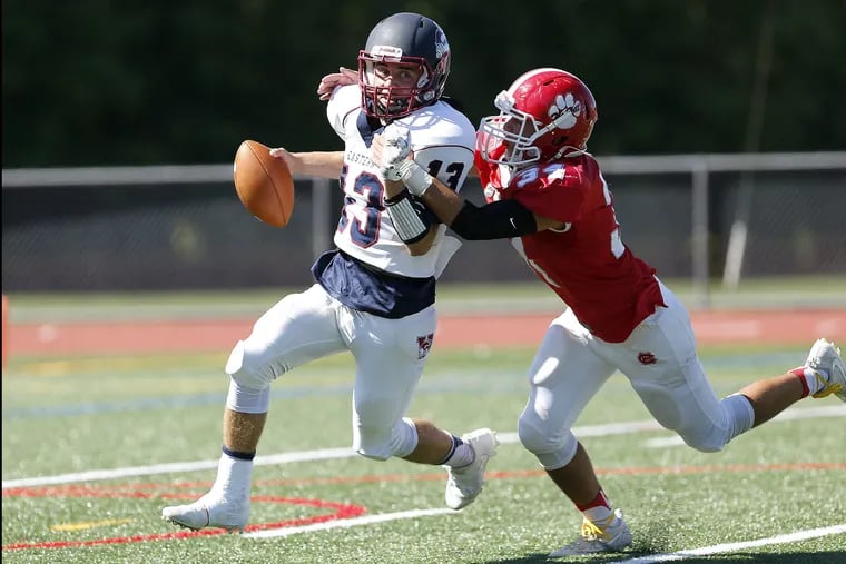 Andrew Heck (left) will compete at the quarterback spot again this season.  Here, he is pursued last season by Cherry Hill East's Sean Coen.