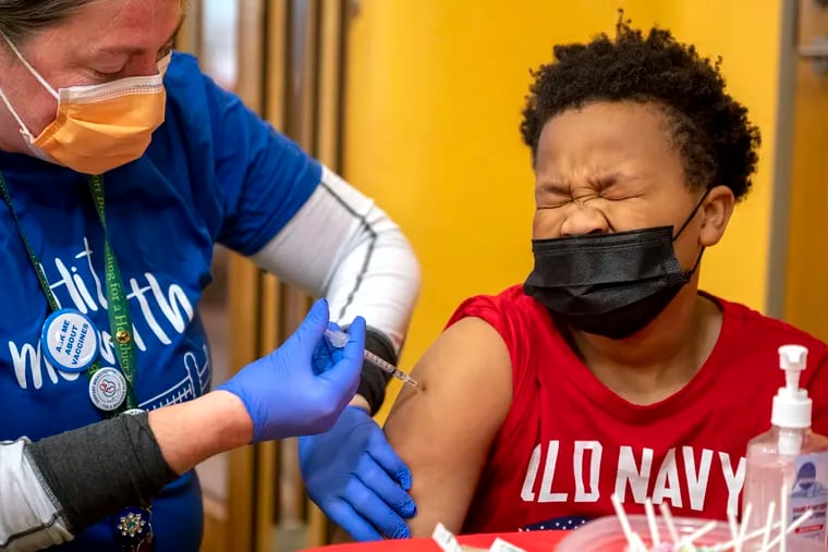 Kerron Jones, 11, of West Philadelphia, gets his first shot from Children’s Hospital of Philadelphia primary care physician Katie McPeak during a COVID-19 vaccine event at the Philadelphia Zoo Dec. 14, 2021.