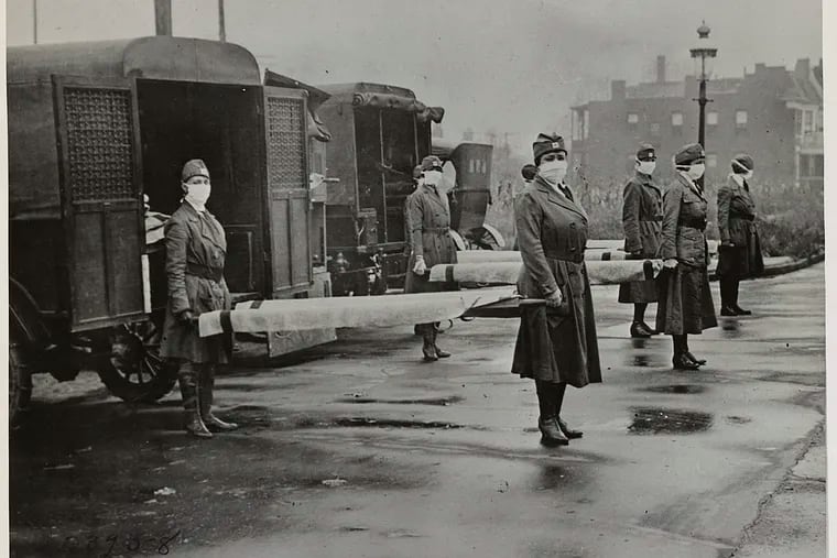 St. Louis Red Cross Motor Corps personnel hold stretchers next to ambulances in preparation of receiving victims of the influenza epidemic in October 1918. MUST CREDIT: Library of Congress
