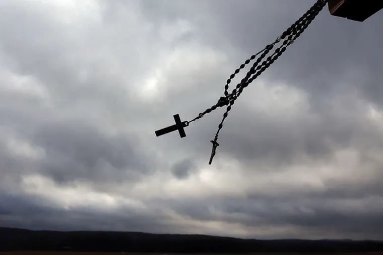 At the crash site of Flight 93 in Shanksville, rosary beads and a crucifix swing in the cold wind in December 2001.