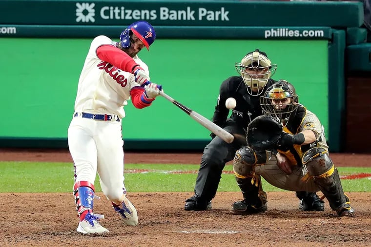 Phillies designated hitter Bryce Harper hits a two-run homer in Game 5 of the National League Championship Series against the San Diego Padres.