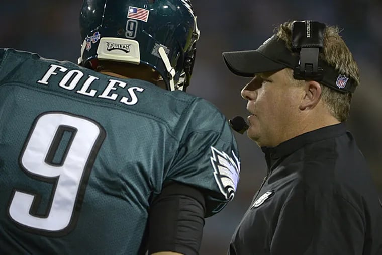Eagles head coach Chip Kelly talks with quarterback Nick Foles. (Phelan M. Ebenhack/AP)