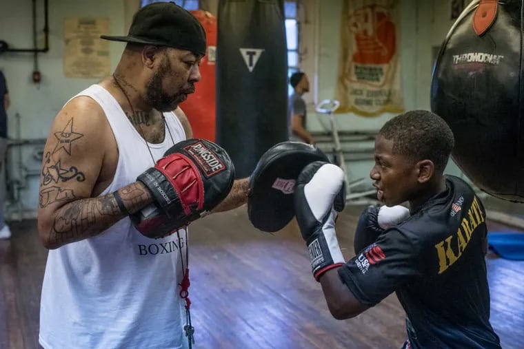 Jamir Torrence, 13, works on punching drills with boxing trainer James Ryan at the Jack Costello Boxing Club in Philadelphia on Monday, July 18, 2016. The club is introducing a summer boxing program to young people as a way to inculcate discipline and focus.