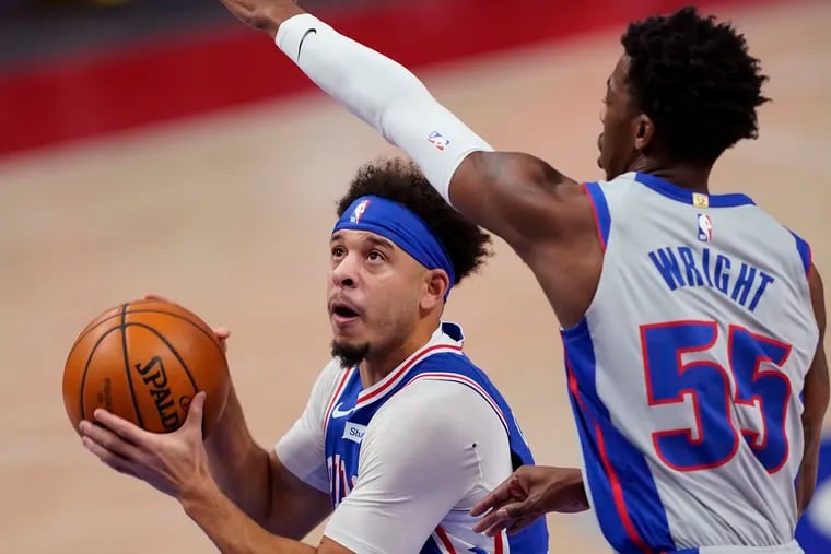 The 76ers' Seth Curry looks toward the basket as Detroit Pistons guard Delon Wright defends.