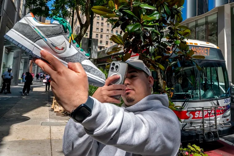 Kevin Muñoz from Hillsboro N.J. photographs his just-purchased pair of the newest Nike Dunk low "Philly" inspired shoe, leaving Lapstone & Hammer on Chestnut Street shortly after the store opened Thursday, May 30, 2024 with an exclusive release.