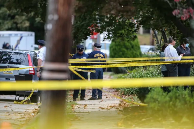 Crime scene investigators work after police fatally shot a man and a Philadelphia police officer was wounded on the 5700 block of Overbrook Avenue.