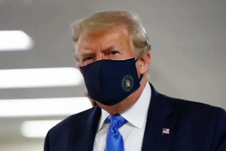 President Donald Trump wears a face mask as he walks down a hallway during a visit to Walter Reed National Military Medical Center in Bethesda, Md., last week.
