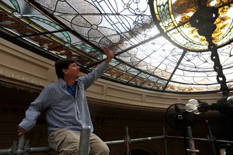 Stained-glass artist Randall Claggett checks the connections of restored stained-glass panel that he installed in the rose ceiling of the old Elkins family mansion in Elkins Park.  September. 27, 2013 ( RON TARVER / Staff Photographer )