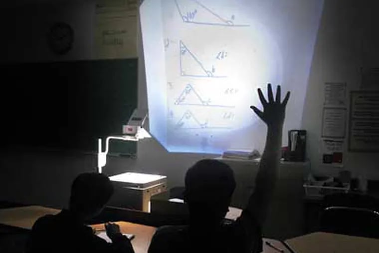 Math problems are displayed on an overhead projector in teacher Bill Davidson's darkened classroom at the Folk Arts and Cultural Treasures Charter School. ( Tom Gralish / Staff Photographer )