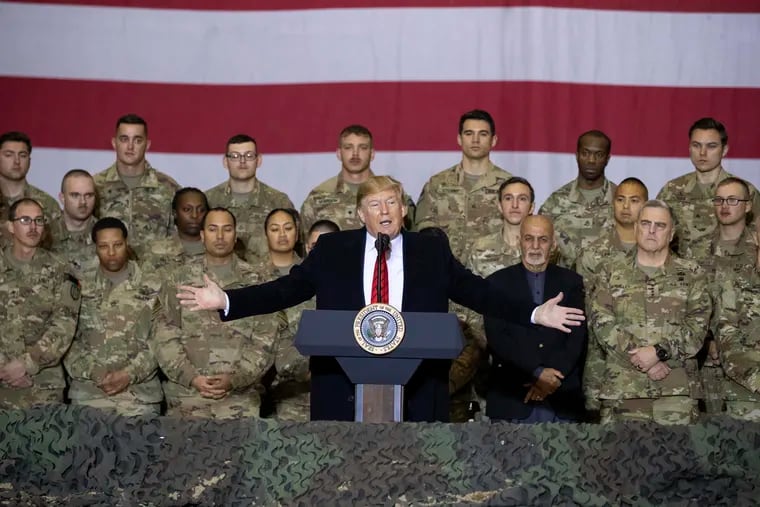 In this Nov. 28, 2019 fphoto, President Donald Trump, center, with Afghan President Ashraf Ghani and Joint Chiefs Chairman Gen. Mark Milley, behind him at right, addresses members of the military during a surprise Thanksgiving Day visit at Bagram Air Field, Afghanistan. During his election campaign four years ago, Trump vowed to bring all troops home from “endless wars." (AP Photo/Alex Brandon, File)